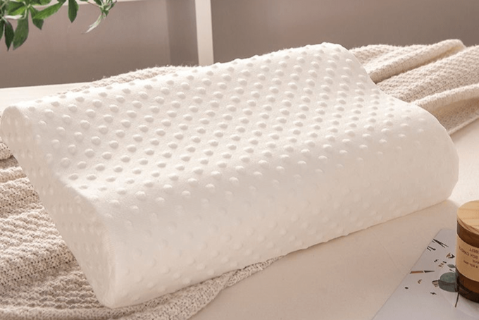 alt="Side view of Spino pillow on bed – breathable and supportive design"